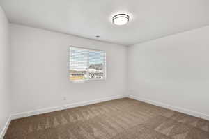 Empty room featuring baseboards and carpet floors