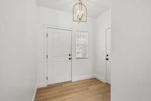 Entryway featuring light wood-style floors and hanging lights