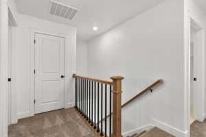 Staircase with carpet flooring and recessed lighting
