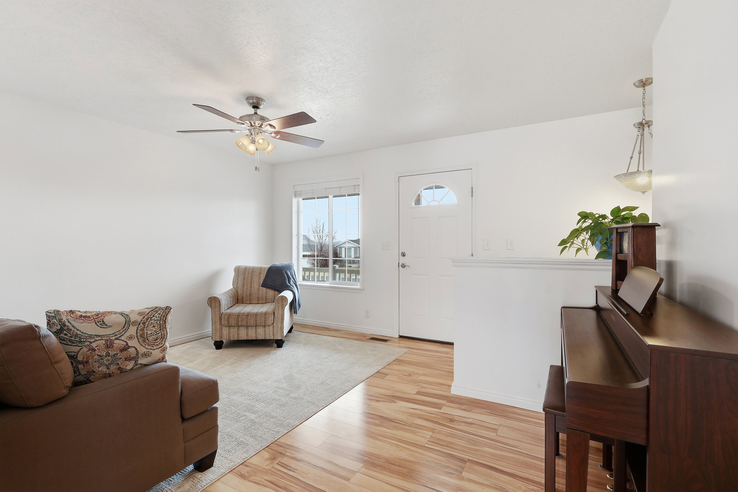 Living room featuring light wood-type flooring and a ceiling fan