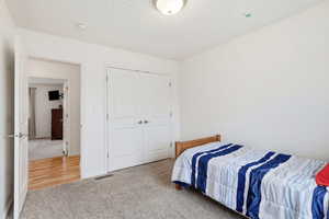 Bedroom with light carpet and a closet