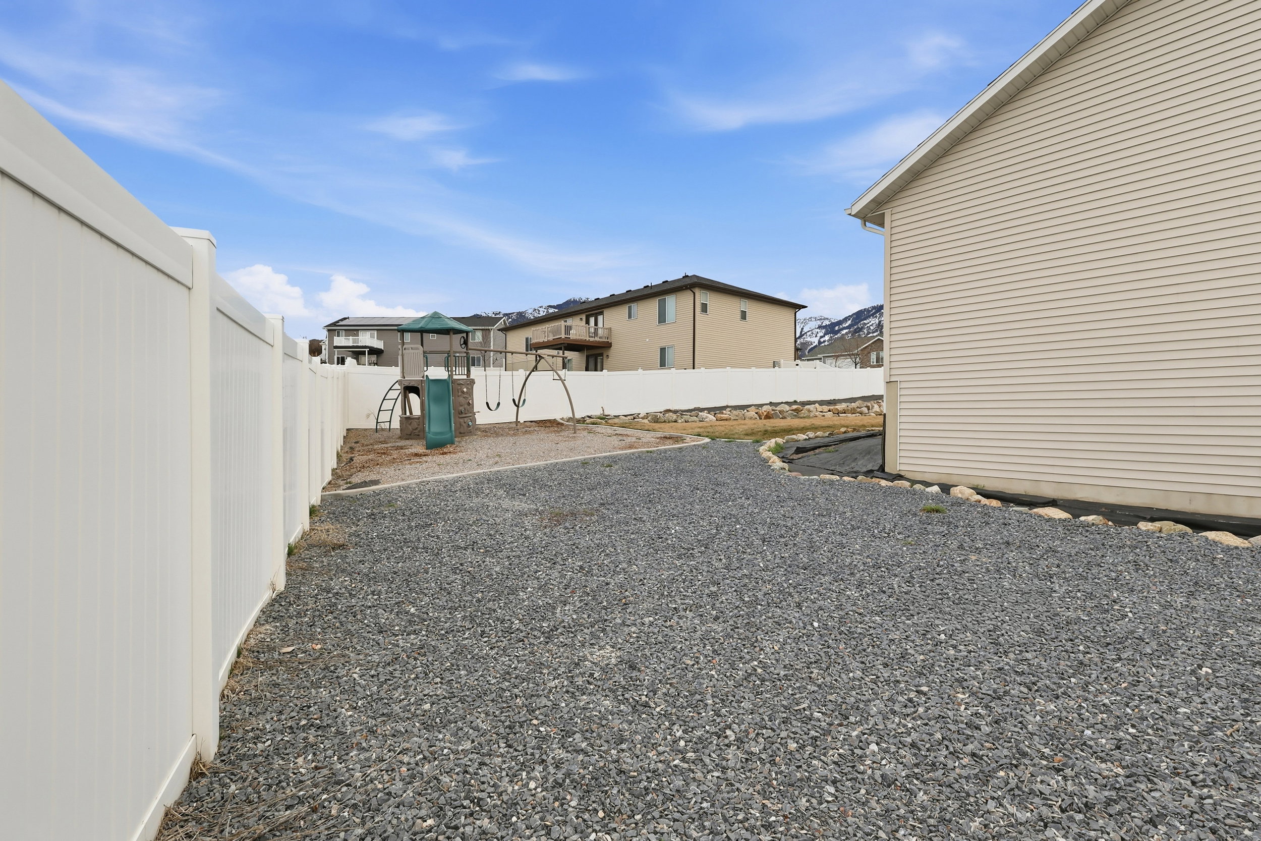 Fenced backyard featuring a playground