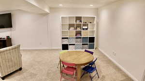 Sitting room with light colored carpet and recessed lighting