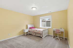 Bedroom featuring light colored carpet and baseboards