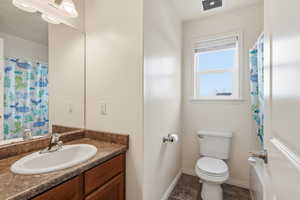 Full bath featuring curtained shower and vanity