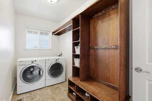 Laundry area featuring independent washer and dryer and stone finish floors
