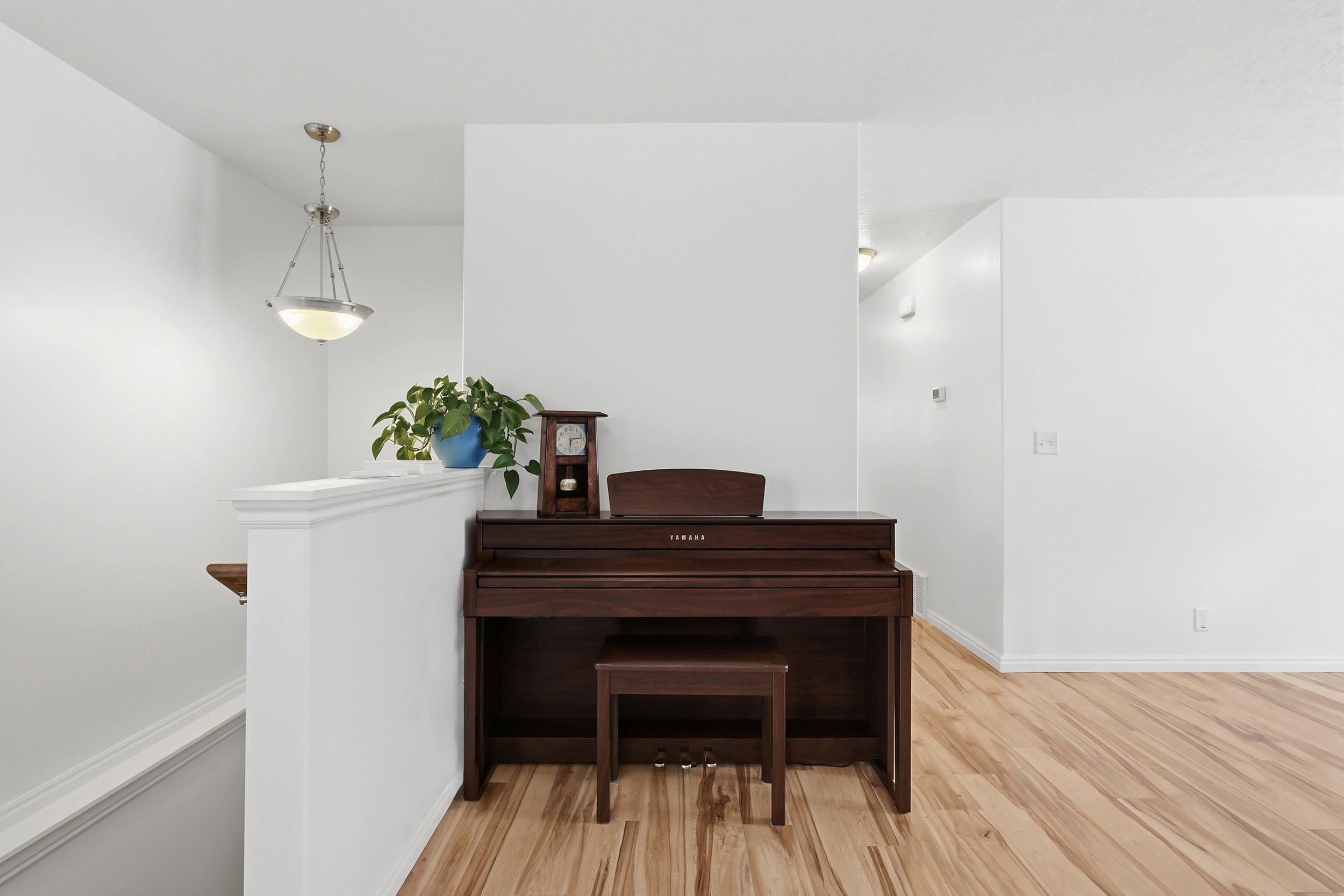 Hall with light wood finished floors and an upstairs landing