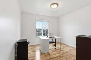Office area featuring light wood-style flooring and baseboards