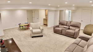 Living area with recessed lighting and light colored carpet