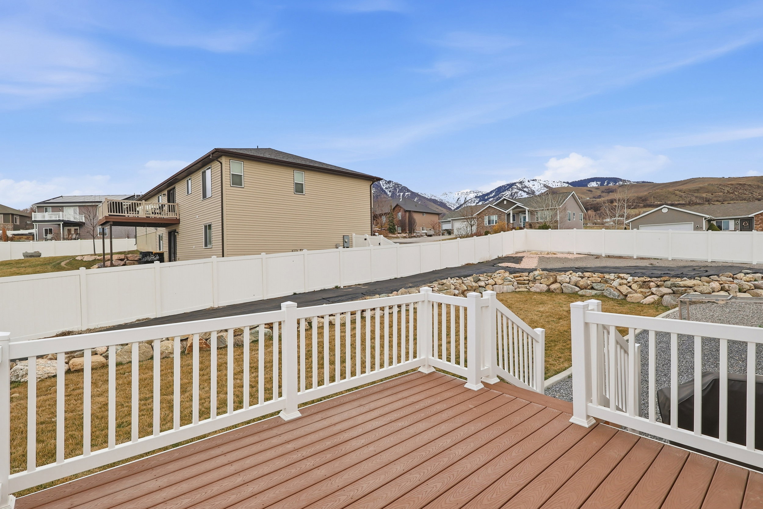 Deck featuring a fenced backyard, a mountain view, and a residential view