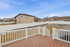 Deck featuring a fenced backyard, a mountain view, and a residential view