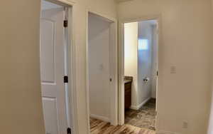 Hallway with light wood-style floors and baseboards