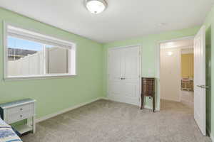 Unfurnished bedroom featuring light colored carpet and a closet