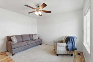 Living area featuring light wood-style floors and a ceiling fan