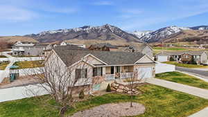 View of front of house featuring a porch, a residential view, driveway, and a mountain view
