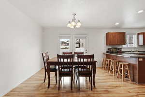 Dining room featuring a chandelier, a textured ceiling, and light wood-style floors