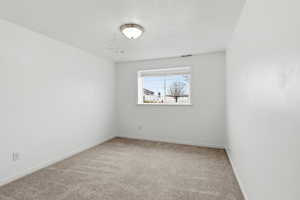 Carpeted spare room with baseboards