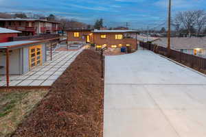 Back of house featuring a patio area, brick siding, and driveway