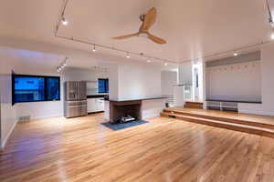 Family room with Frank LLoyd Wright style fireplace, ceiling fan, and track lighting
