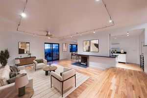 Living room featuring track lighting, light wood-type flooring, and a ceiling fan
