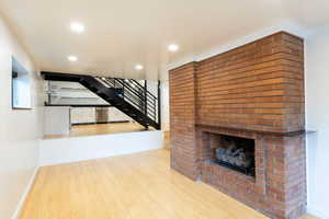 living room with bamboo finished floors, a fireplace, and recessed lighting