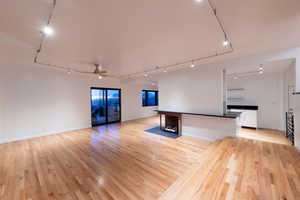 family room with custom solid oak floors, track lighting, and ceiling fan