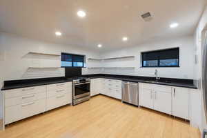 Kitchen featuring GE PROFILE stainless steel appliances, white cabinetry, modern cabinets, and open shelves