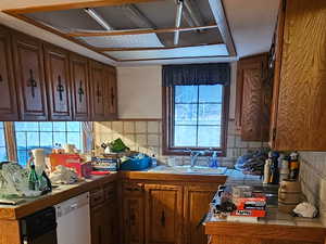 Kitchen with a peninsula, wood finish cabinets, light wood finished floors, and white dishwasher