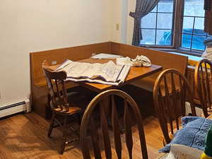 Semi-Dining space with hardwood / wood-style flooring, a ceiling fan, built in seating