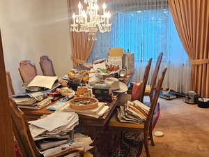 Carpeted dining room with a chandelier
