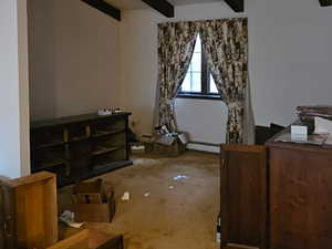 Another View of Primary Bedroom with carpet floors and vaulted ceiling with beams