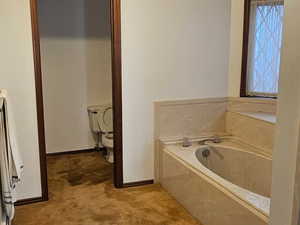 Primary Bathroom featuring dark carpet, a garden tub, and ornamental molding