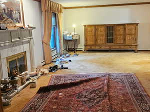 Huge Living area with a tiled fireplace, light carpet, and ornamental molding