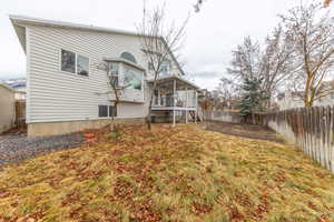 Rear view of house with a fenced backyard and a deck