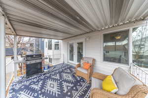 Wooden deck featuring area for grilling and french doors