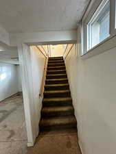 Stairs featuring a textured ceiling