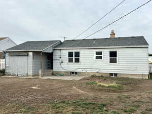 Rear view of property with roof with shingles, a patio area, and a chimney