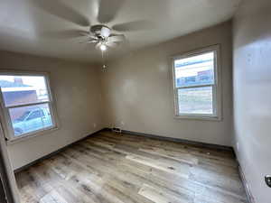 Empty room with light wood-style floors and ceiling fan