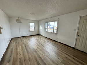 Unfurnished room with hardwood / wood-style flooring and a textured ceiling