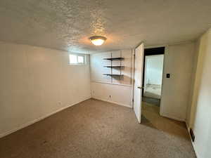 Unfurnished bedroom featuring a textured ceiling and carpet