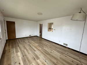 Unfurnished room featuring light wood-style floors and a textured ceiling