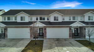 Traditional-style home featuring roof with shingles, an attached garage, driveway, and brick siding