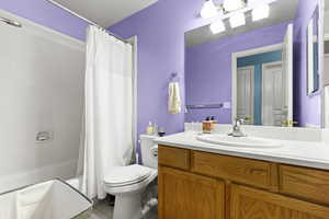 Full bathroom featuring vanity, shower / bath combination with curtain, and tile patterned flooring