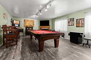 Playroom featuring a textured ceiling, billiards table, wood finished floors, and rail lighting