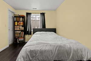 Bedroom featuring dark wood finished floors and baseboards