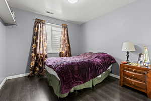Bedroom with dark wood-style floors and a textured ceiling