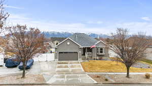 Ranch-style home with a gate, driveway, stucco siding, a mountain view, and a garage