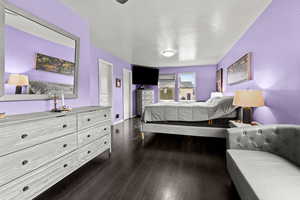 Bedroom featuring dark wood-type flooring and baseboards