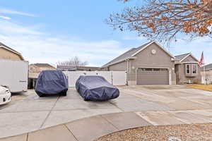 View of side of home with a gate, stucco siding, concrete driveway, and a garage