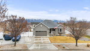 Ranch-style house with a shingled roof, concrete driveway, a gate, stucco siding, and a garage